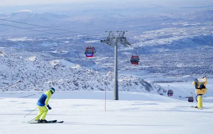 Erciyes Kayak Merkezi’nde gondol hattı ve geniş pistlerde kayak yapan sporcu